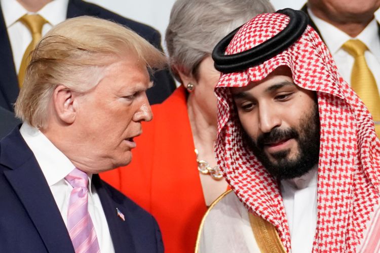 Presiden Amerika Serikat Donald Trump berbicara dengan Pangeran Mahkota Arab Saudi Mohammed bin Salman saat foto bersama dengan pemimpin lainnya dalam Konferensi Tingkat Tinggi G20 di Osaka, Jepang, Jumat (28/6/2019).