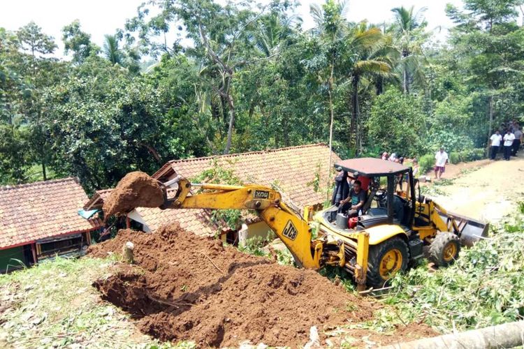 Alat berat diterjunkan untuk membuka kembali akses jalan Cikeusal-Singaparna Kabupaten Tasikmalaya yang tertutup material tanah longsoran, Rabu (22/1/2020).