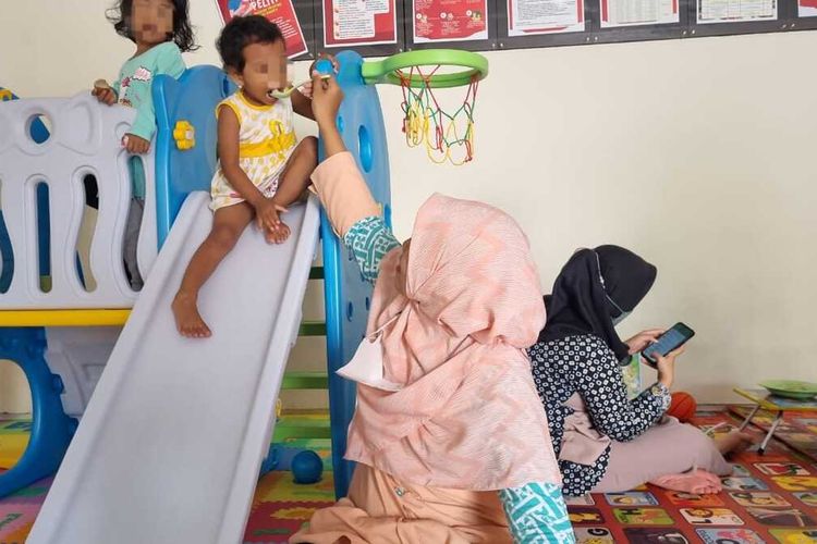 Pengasuh di daycare Rumah Pelita milik Pemkot Semarang menyuapi anak-anak yang dititipkan orangtuanya, Senin (3/4/2023).