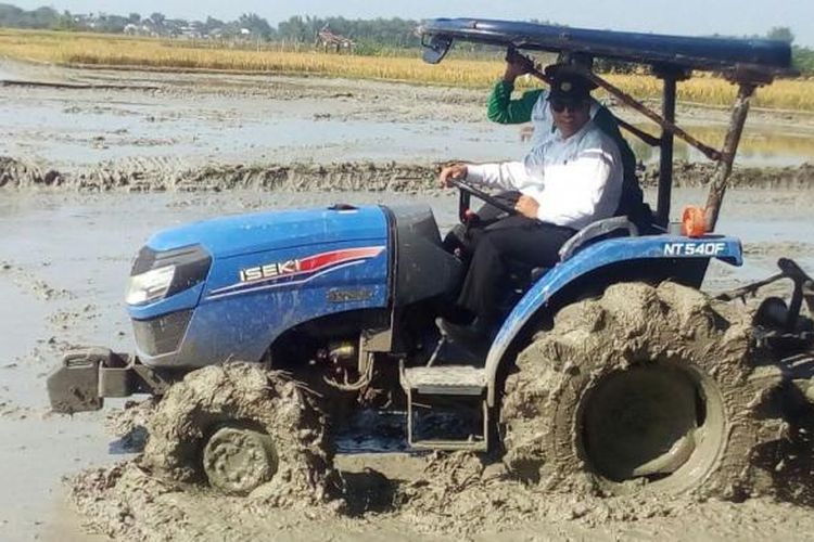 Menteri Pertanian Andi Amran Sulaiman (berkemeja putih) mencoba traktor pembajak sawah di Desa Samberan, Kecamatan Kanor, Kabupaten Bojonegoro, Jaw Timur pada Selasa (7/3/2017). Sebagai salah satu lumbung beras Jawa Timur, Kabupaten Bojonegoro menyumbang 1,057 juta ton beras pada sepanjang 2016. 