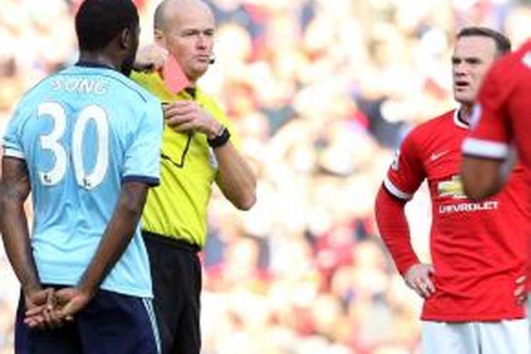 Penyerang Manchester United, Wayne Rooney (kanan), mendapat kartu merah dari wasit Lee Mason karena melanggar pemain sayap West Ham United, Stewart Downing, pada laga Premier League, di Old Trafford, 27 September 2014.