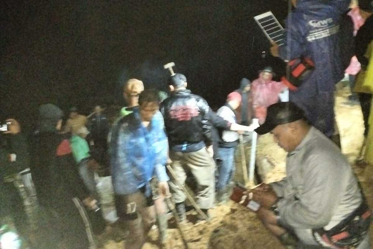 Warga dan aparat pemerintah, TNI/Polri berusaha melakukan pembersihan material longsoran di Kampumg Sirnagalih, Desa Talagajaya, Kamis (26/04/2024) malam