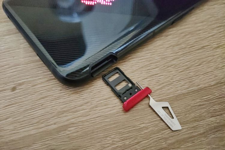 Bagian bingkai kiri ROG Phone 5. Di sisi ini terdapat slot kartu SIM (dual nano-SIM) dengan modul berwarna merah yang bisa ditarik keluar dengan mencolokkan SIM ejector ke lubang yang berada di sebelahnya. 