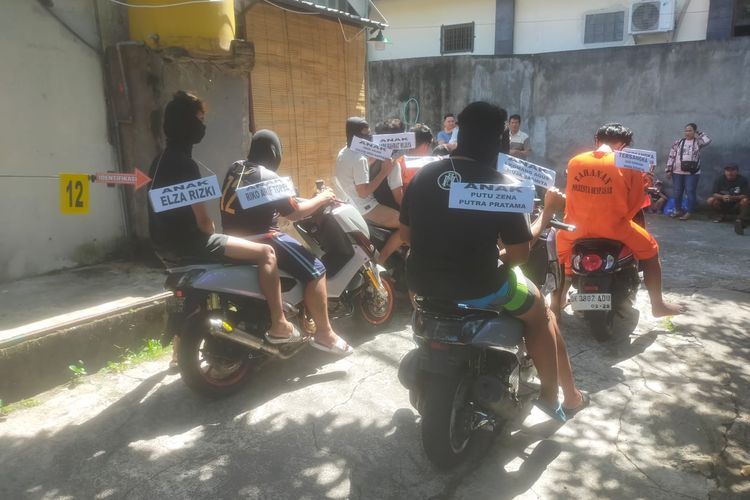 Sepuluh orang tersangka kasus pembunuhan seorang juru parkir, Yohanes Imanuel Naioki (33), saat memperagakan adegan dalam rekontruksi yang digelar di Asrama Polisi Polresta Denpasar, pada Kamis (15/6/2023). /Humas Polresta Denpasar