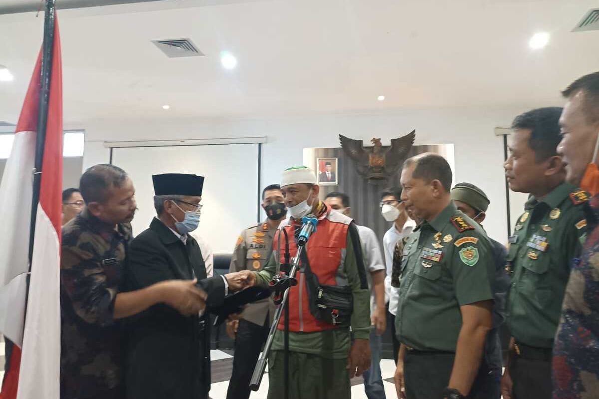 Ketua MUI Karawang Tajudin Nur memberikan peci kepada anggota organisasi Khilafatul Muslimin yang berikrar setia kepada NKRI dan Pancasila di Aula Lantai 3 Gedung Singaperbangsa, Komples Kantor Pemkab Karawang, Rabu (29/6/2022).