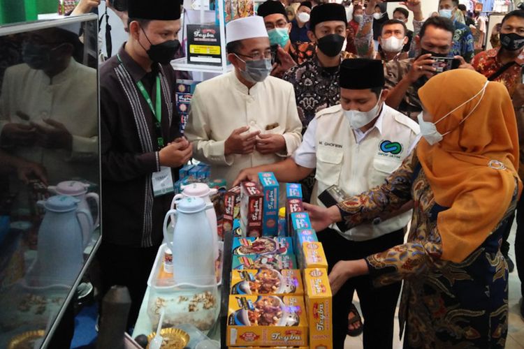 Gubernur Jawa Timur Khofifah Indar Parawansa (kanan), sempat memborong produk yang dipamerkan oleh salah satu pondok pesantren di Jawa Timur dalam expo OPOP, Minggu (28/11/2021).