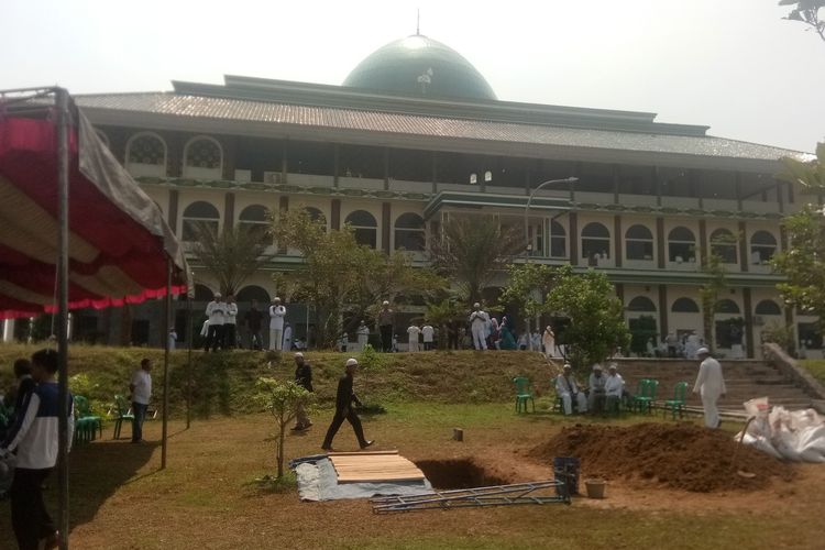 Sejumlah pelayat nampak melihat liang lahat yang dipersiapkan untuk mengebumikan jenazah Ustaz Arifin Ilham di komplek Pondok Pesantren Az-Zikra, Gunung Sindur, Kabupaten Bogor, Kamis (23/5/2019)