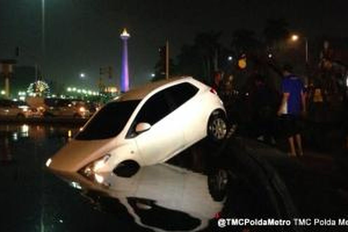 Mobil Mazda 2 bernomor polisi B 1716 FKM masuk ke kolam Bundaran depan Bank Indonesia, Jalan MH Thamrin, Senin (15/7/2013) subuh.