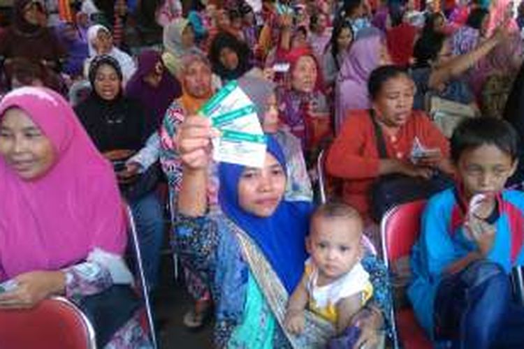 Peserta menunjukkan Kartu Indonesia Sehat saat pencairan dana Program Keluarga Harapan di Kantor Pos Surabaya Selatan, Kota Surabaya, Jawa Timur, Sabtu (25/6/2016).