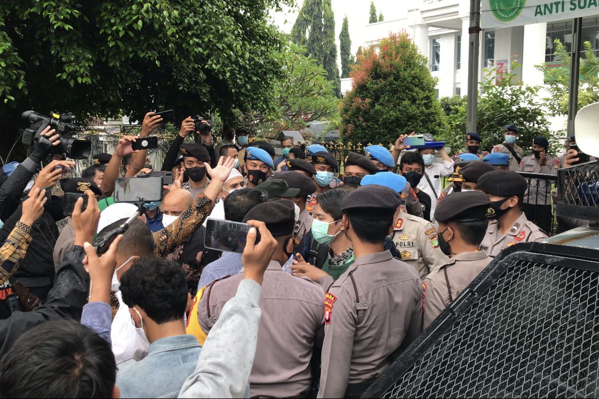 Anggota tim kuasa hukum terdakwa kasus kerumunan dan penghasutan, yaitu Rizieq Shihab, cekcok dengan polisi di depan Pengadilan Negeri Jakarta Timur (PN Jaktim), Cakung, Jakarta Timur pada Selasa (30/3/2021).