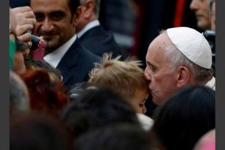 Paus Fransiskus mencium bocah setelah mengunjungi Katedral San Rufino di Assisi, Italia, 4 oktober 2013.