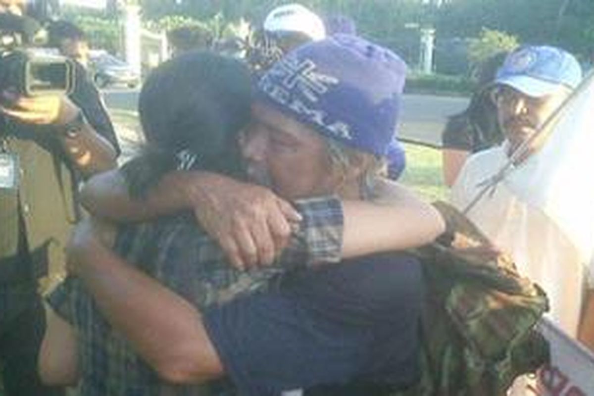 Indra Azwan, warga Malang yang berjalan kaki ke Jakarta, berpelukan dengan salah satu anaknya, di dekat Istana Negara, Jakarta, Jumat (30/7/2010) sore.