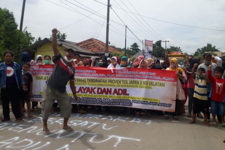 Puluhan warga Kampung Citaman, Desa Tamansaru, Kecamatan Pangkalan, Kabupaten Karawang memblokade jalan Badami-Loji, Sabtu (2/1/2021). Aksi itu dilakukan sebagai protes ganti rugi pembebasan lahan tol Jakarta-Cikampek II yang dihargai murah.
