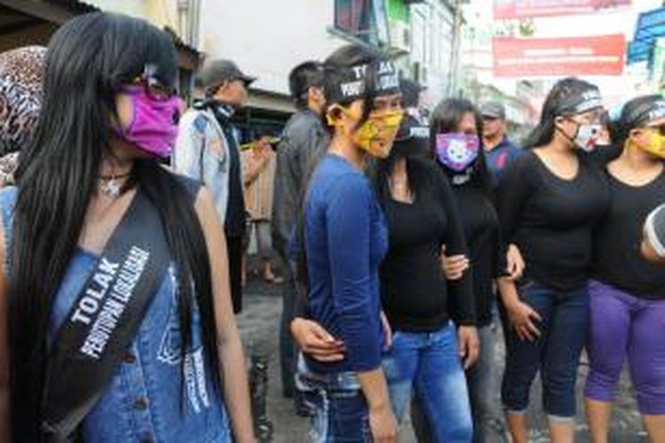 Sejumlah orang yang terdiri dari warga dan pekerja seks komersial (PSK) bersiap melakukan aksi menolak penutupan kawasan prostitusi Dolly dan Jarak, di Surabaya, Rabu (18/6/2014). Dalam aksi yang disertai pembakaran surat undangan, warga di kawasan prostitusi tersebut menolak menghadiri deklarasi penutupan yang rencananya akan digelar hari ini di Islamic Center, Jalan Dukuh Kupang, Surabaya.