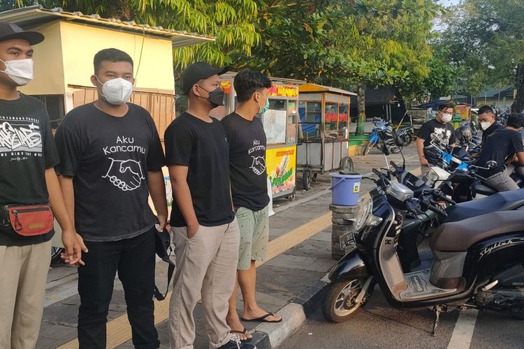 Para pemuda dengan kaos hitam tulisan Aku Kancamu di alun-alun Wates, Kabupaten Kulon Progo, Daerah Istimewa Yogyakarta.