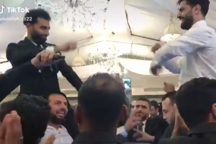 Foto layar dari rekaman video yang menangkap penyerang Liverpool, Mohamed Salah, berdansa di tengah kerumunan orang dan tak memakai masker pada acara pernikahan adiknya, Nasr Salah, pada Selasa (10/11/2020). 