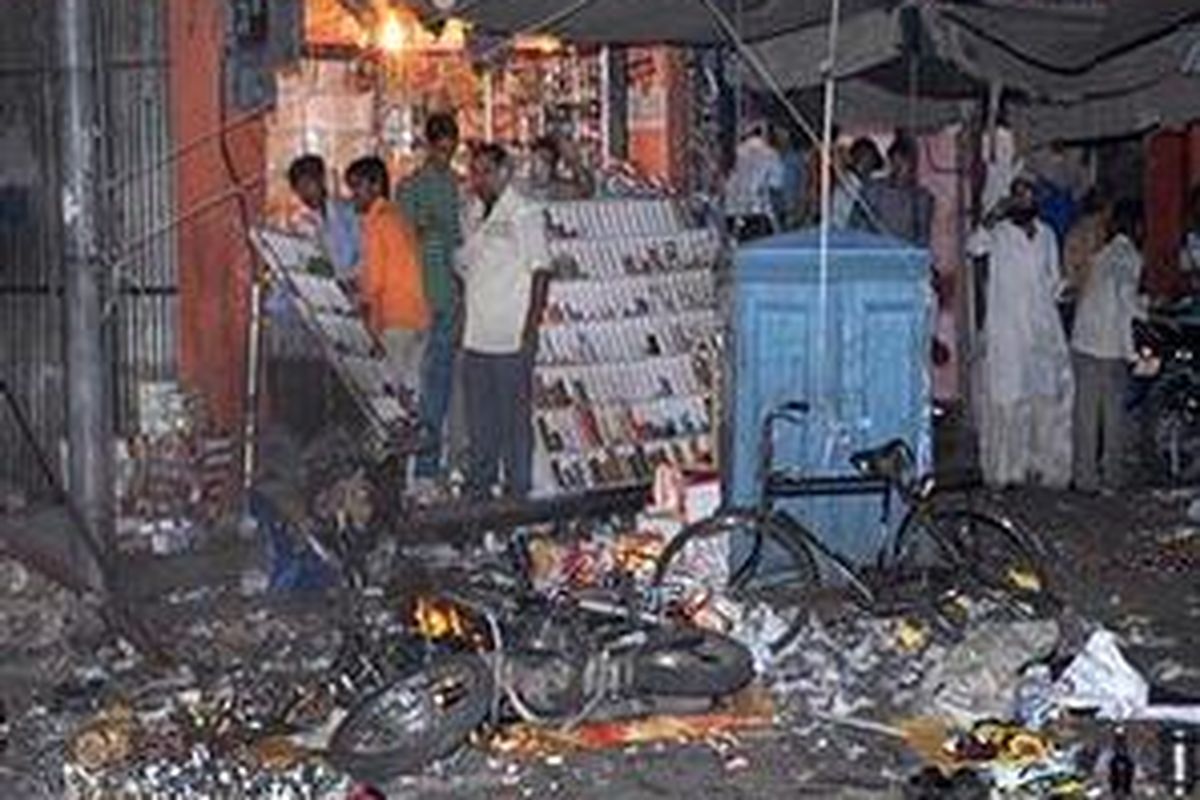 Beberapa warga India menyaksikan salah satu lokasi yang menjadi target ledakan bom di pasar padat pengunjung di kota Jaipur, 13 Mei 2008. 