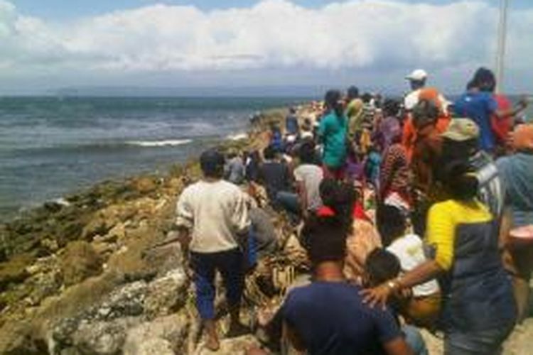 Warga di sekitar laut selatan Puger, Jember, Jawa Timur, sedang melihat puing perahu yang hancur akibat dihantam ombak, Jumat (27/9/13)