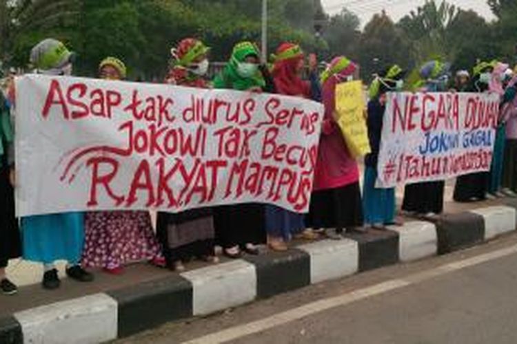 Aksi unjuk rasa puluhan mahasiswa yang tergabung dalam Kesatuan Aksi Mahasiswa Muslim Indonesia (KAMMI) Kalimantan Barat dalam peringatan satu tahun pemerintahan Jokowi-JK di Bundaran Digulis, Jalan Ahmad Yani, Pontianak (20/10/2015)