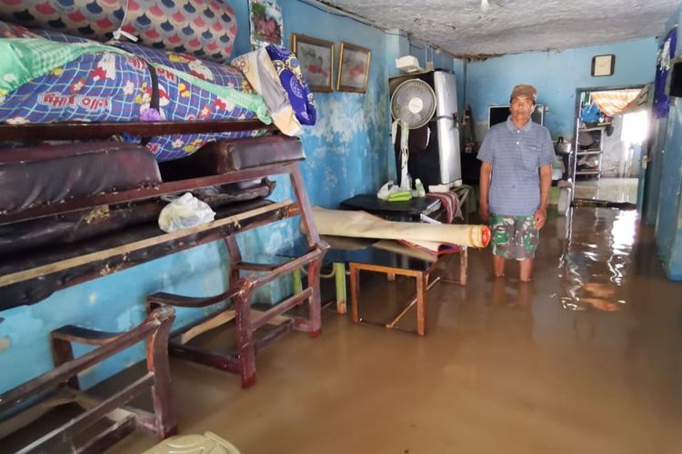 Warga mengamankan perabotan rumah tangga akibat rumahnya terendam banjir, Senin (14/3/2022)