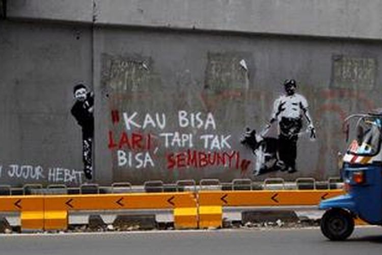Bajaj melintas di depan mural anti korupsi di Jalan Salemba, Jakarta Pusat, Senin (10/12/2012). Kritikan terhadap pelaku koruptor terus disuarakan oleh aktivis untuk mendorong tindakan lebih tegas dalam pemberantasan korupsi dan penegakan hukum lainnya.
