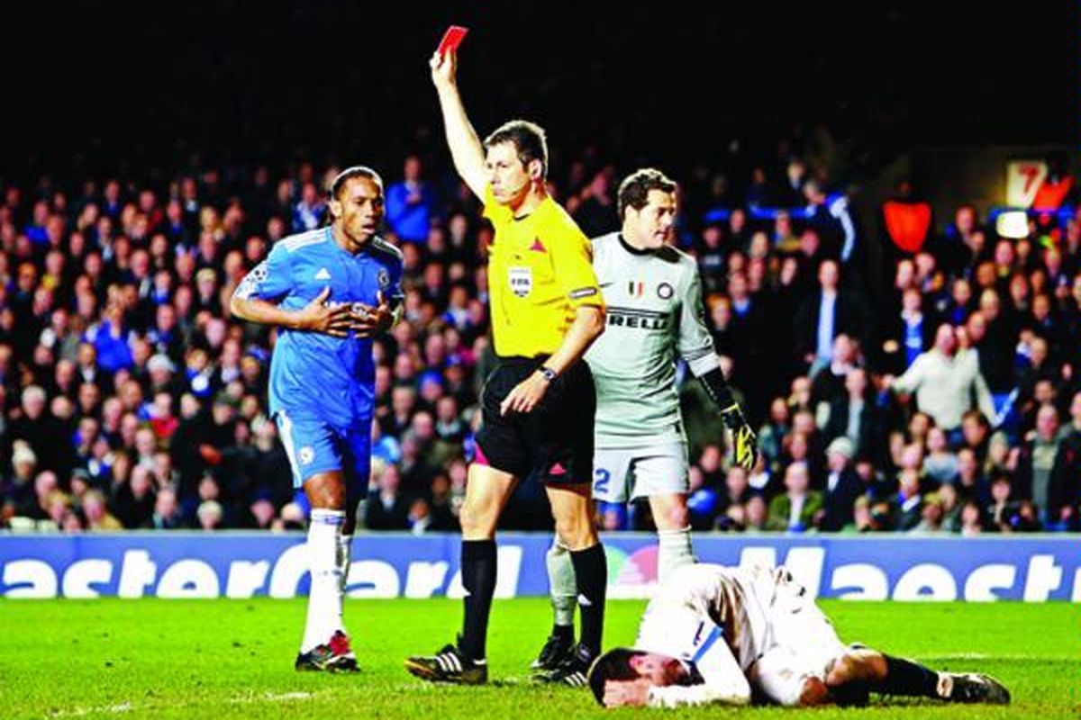 Striker Chelsea, Didier Drogba (kiri), tertegun saat wasit Wolfgang Stark mengeluarkan kartu merah atas tindakan kasar Drogba terhadap gelandang Inter Milan, Thiago Motta (terbaring), pada laga Liga Champions di Stamford Bridge, London, Inggris, Selasa (16/3). Chelsea menyerah 0-1.