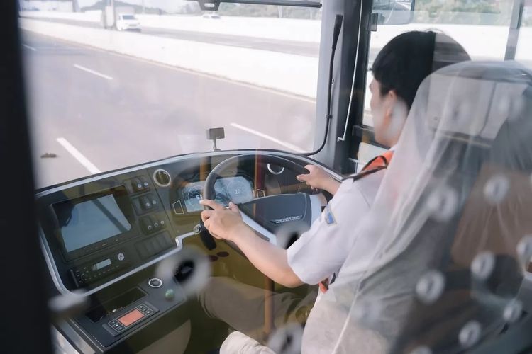 Seorang sopir bus sedang mengendarai bus listrik Zhongtong