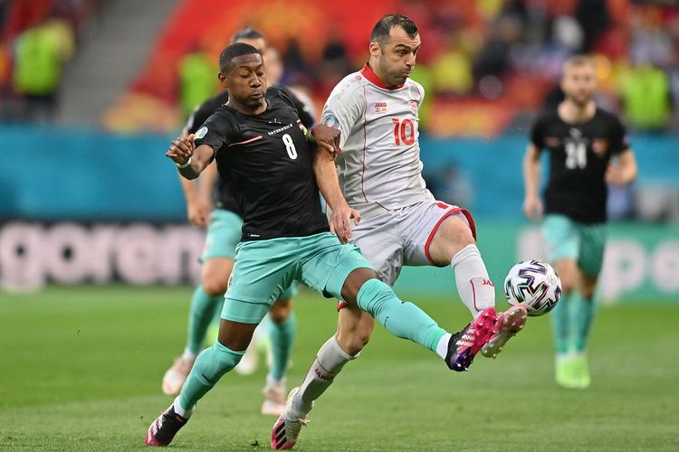 Pemain Austria David Alaba berduel dengan penyerang Makedonia Utara Goran Pandev pada laga pembuka Grup C di Stadion Bucharest, Minggu (13/6/2021) malam WIB.