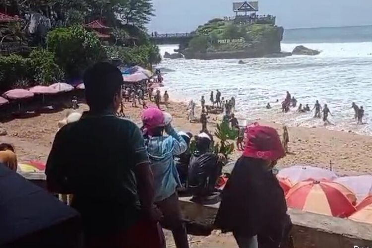 Wisatawan berlari menghindari gelombang di Pantai Kukup, Tanjungsari, Gunungkidul. Minggu (3/3/2024)