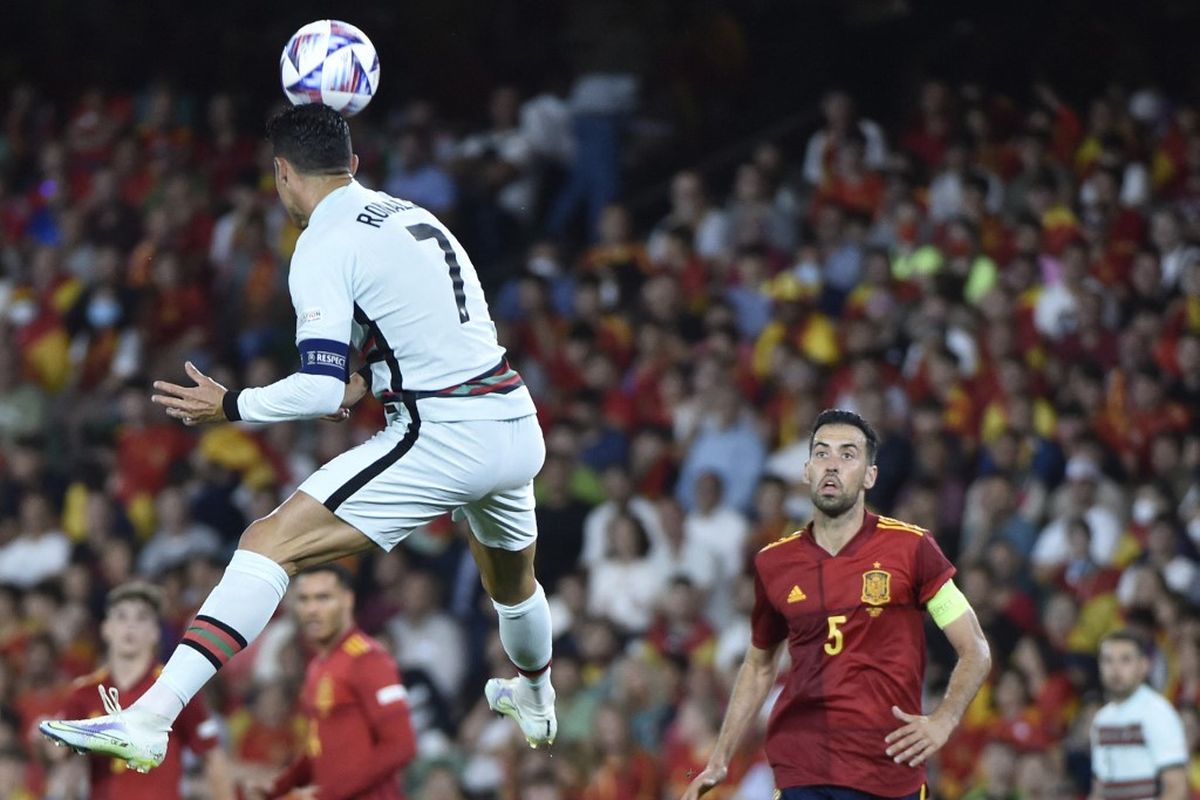 Sergio Busquets (kanan) menyaksikan Cristiano Ronaldo menyundul bola dalam pertandingan Spanyol vs Portugal pada fase Grup 2 Liga A UEFA Nations League di Stadion Benito Villamarin, Jumat (3/6/2022). 