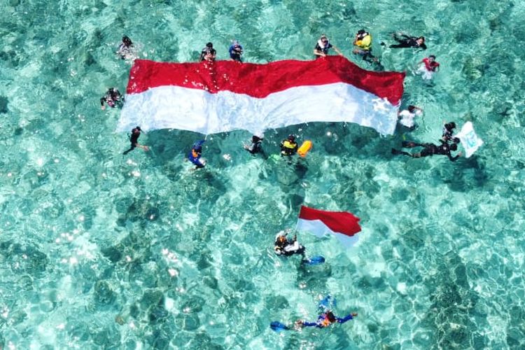 Para penyelam membentang bendera Merah Putih di patahan tsunami tahun 1992 teluk Maumere, Kabupaten Sikka, NTT, Senin (17/8/2020). 