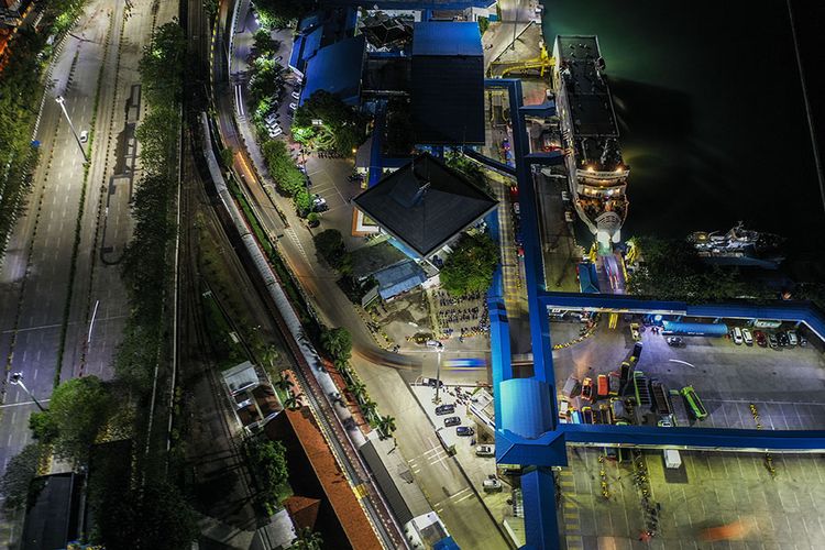 Foto aerial kendaraan logistik tujuan Sumatera antre memasuki kapal di Pelabuhan Merak Banten, Kamis (21/5/2020) malam. Menjelang Hari Raya Idul Fitri 1441 H, arus penyeberangan penumpang di Pelabuhan Merak mengalami penurunan penumpang hingga 98,3 persen jika dibandingkan periode yang sama pada tahun lalu dikarenakan adanya aturan larangan mudik dari pemerintah demi mencegah penyebaran pandemi COVID-19.