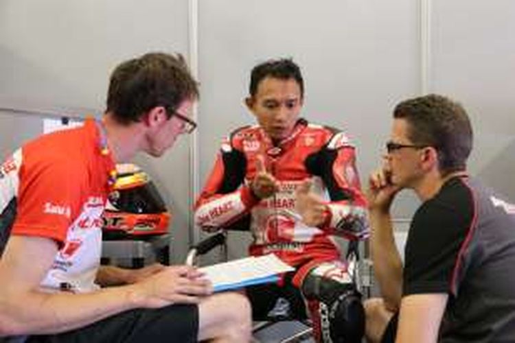 Pebalap Astra Honda Racing Team asal Indonesia, Dimas Ekky Pratama, berdiskusi dengan tim saat menjalani sesi latihan Moto2 European Championship di Sirkuit de Barcelona-Catalunya, Jumat (10/6/2016).