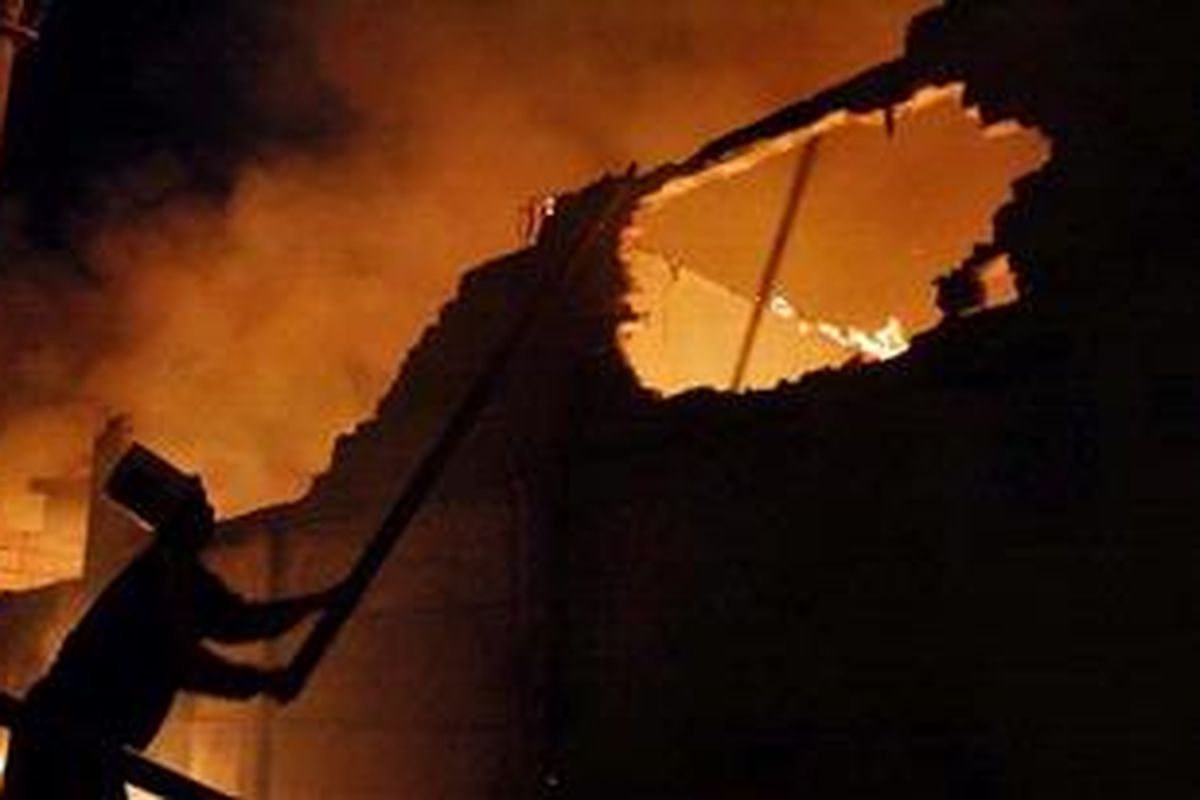 Warga berusaha memadamkan api dengan alat seadanya pada kebakaran yang melalap pemukiman di Kampung Duri Selatan, Jakarta Barat, Kamis (7/2/2013). Akibat besarnya api puluhan rumah yang berada di tepi rel kereta itu habis terbakar.