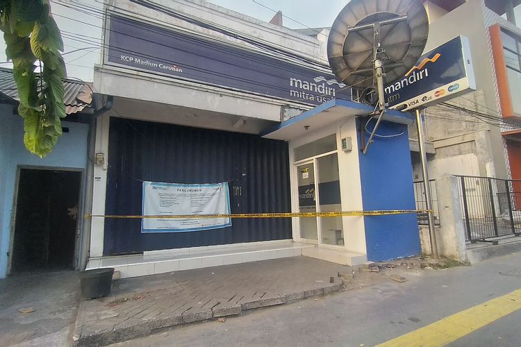 Aparat Polsek Mejayan memberi garis polisi pada mesin ATM Bank Mandiri Kantor Cabang Pembantu Caruban di Jalan Panglima Sudirman, Kecamatan Mejayan, Kabupaten Madiun yang hendak dibobol maling, Selasa (24/10/2023)