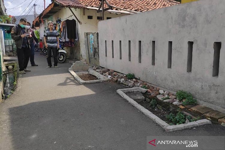 Warga melintas di dekat makam yang berada di jalan umum kawasan Pisangan Lama, Jakarta Timur, Selasa (16/6/2020). Warga setempat menyebutkan jika makam keluarga itu ada sejak 1940. 