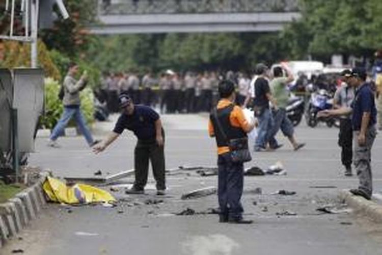 Polisi memeriksa puing-puing di lokasi setelah ledakan menghantam kawasan Jalan MH Thamrin, Jakarta Pusat, 14 Januari 2016. Serangkaian ledakan menewaskan sejumlah orang, terjadi baku tembak antara polisi dan beberapa orang yang diduga pelaku.
