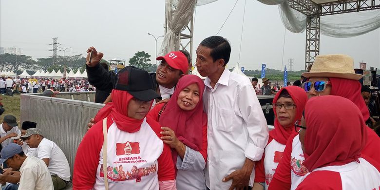 Sejumlah warga berebut untuk berfoto bersama Jokowi di acara Visi Indonesia di Sentul, Bogor, Minggu (14/7/2019)