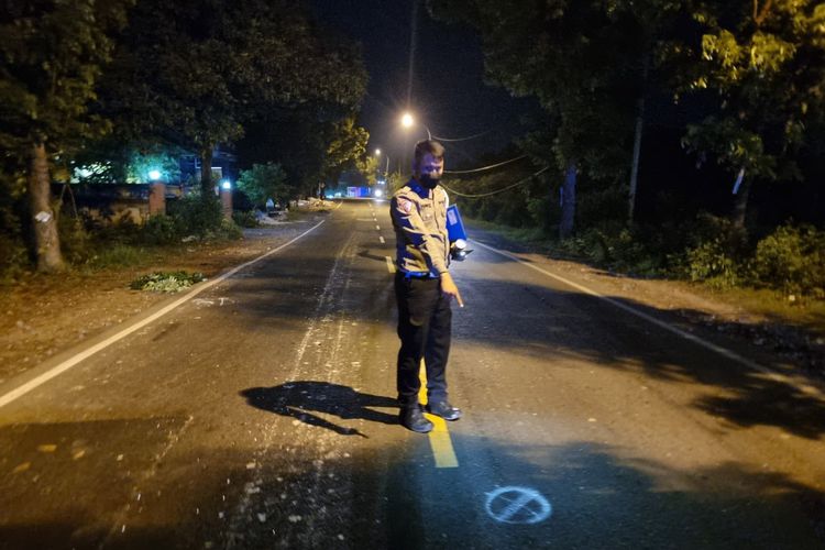 Petugas kepolisian saat menunjukkan lokasi terjadinya kecelakaan lalu lintas di Jalan Raya Desa Abar-abir, Kecamatan Bungah, Gresik, Jawa Timur.