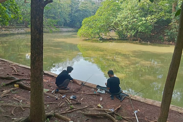 Pengunjung memancing di Hutan Kota Srengseng.