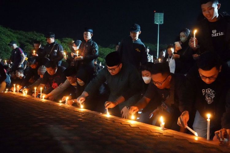 Aksi peletakan 1.000 lilin oleh Bupati Kediri Hanindhito Himawan Pramana dan Kapolres Kediri Agung Setyo Nugroho bersama ratusan suporter sepak bola sebagai tanda belasungkawa untuk korban tragedi Kanjuruhan di Stadion Canda Bhirawa, Kecamatan Pare, Kabupaten Kediri, Jawa Timur, Senin (3/10/2022) 