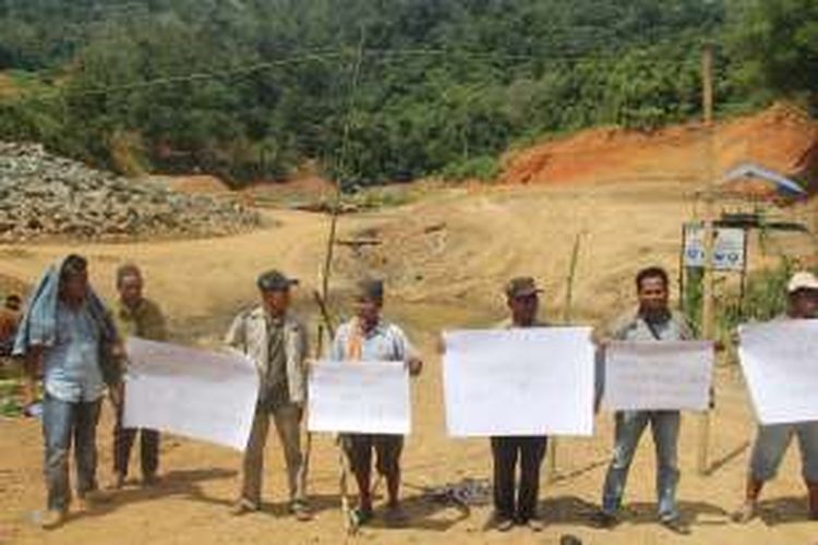 Warga adat dari Desa Pipitak Jaya dan Harakit, Kecamatan Piani, Kabupaten Tapin, Kalimantan Selatan membentangkan karton putih bertuliskan tuntutan warga saat menggelar aksi di lokasi proyek Bendungan Tapin di Pipitak Jaya, Minggu (16/10/2016). Aksi penutupan lokasi proyek dengan ritual adat itu dilakukan warga dalam rangka menuntut penyelesaian pembayaran lahan.