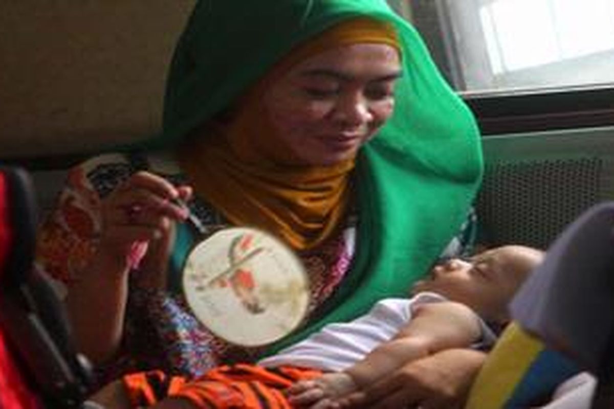 Saksi Wa Ode - Terdakwa anggota Badan Anggaran (Banggar) DPR RI Wa Ode Nurhayati terlihat menghabiskan waktunya dengan mengasuh anak angkatnya Guntur Ibrahim Hasibuan, saat menunggu di mulai sidang dengan agenda mendengarkan keterangan saksi-saksi di pengadilan Tindak Pidana Korupsi (TIPIKOR), Jakarta, Selasa (7/8/2012).  