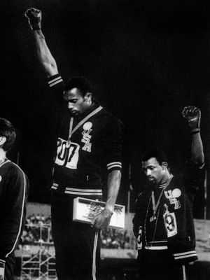 Dua sprinter Amerika Tommie Smith dan John Carlos mengepalkan genggaman dan menaikkan tangan mereka di podium pada seremoni pengalungan medali event 200 meter di Olimpiade Meksiko 1968.