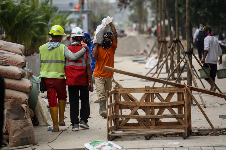 Pekerja menyelesaikan revitalisasi trotoar dan taman di kawasan jalan Sudirman, Jakarta Pusat, Kamis (19/7/2018). Penataan trotoar dan taman ditargetkan selesai pada akhir bulan Juli sebelum pelaksanaan Asian Games 2018.