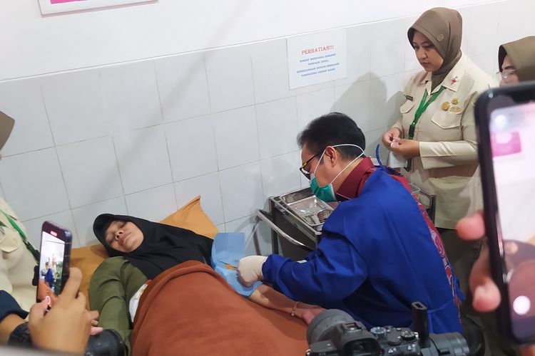 Kepala BKKBN dr Hasto Wardoyo memasang implan kepada seorang ibu saat melayani pemasangan alat kontrasepsi di Klinik Siliwangi pada gelaran puncak peringatan Hari Kontrasepsi Sedunia atau World Contraception Day (WCD) 2023 di Kota Cimahi, Jawa Barat, Senin (23/10/2023). 