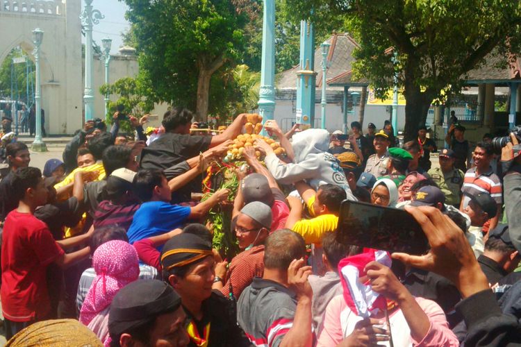 Warga ngalap berkah gunungan garebek besar Keraton Surakarga di depan Masjid Agung Surakarta, Solo, Jawa Tengah, Rabu (22/8/2018).