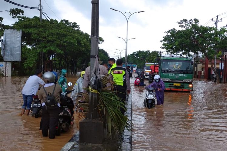 Pengendara yang melintas menuntun motornya melewati banjir di kawasan Mangkang, Sabtu (6/2/2021).