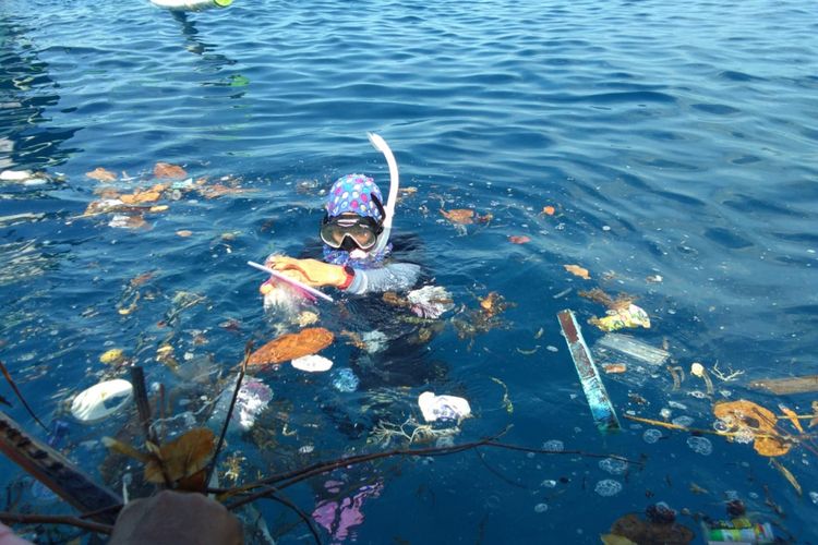 Alana Sastra, gadis kecil pengunjung pantai Botubarani turut membersihkan sampah yang mengapung di permukaan laut.