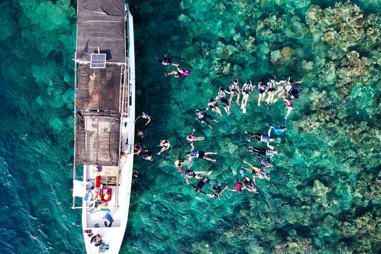 Turis di Maer, Pulau Menjangan Kecil, Karimunjawa sedang berwisata snorkeling. Berikut informasi tarif penyeberangan Jepara-Karimunjawa 2024 dan cara pembelian tiket via laman Ferizy.
